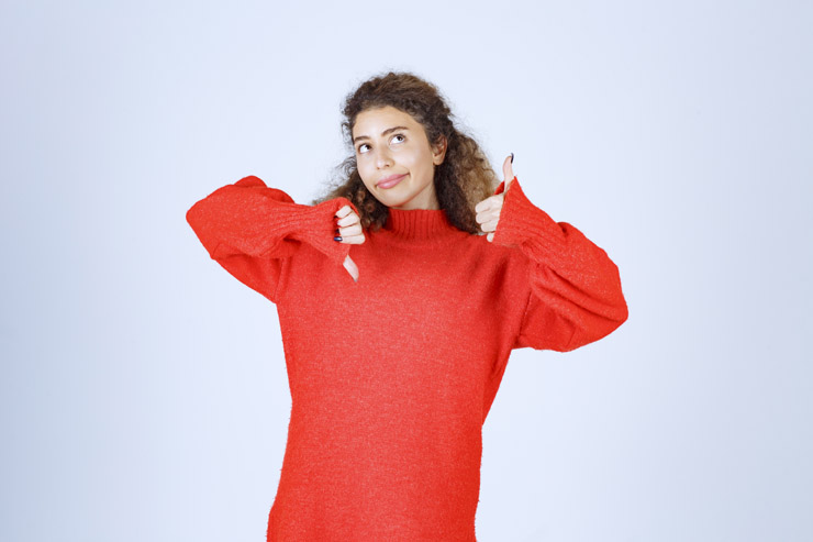 Girl in red sweatshirt showing thumb up and down signs