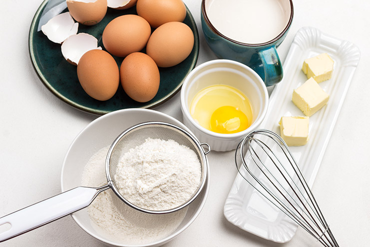 Flour in sieve and in bowl. Butter and whisk on plate. Egg yolk
