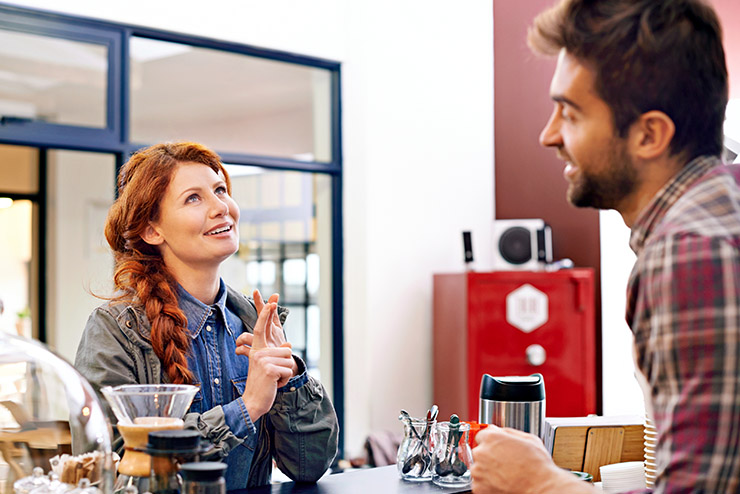 Woman, customer service and waiter in a cafe, counter and decisi