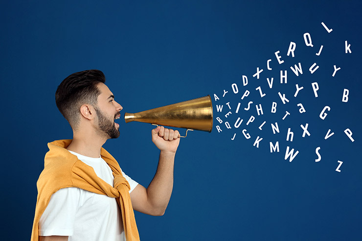 Young man with megaphone on blue background