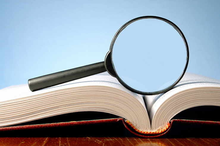 book and a magnifying glass on a blue background