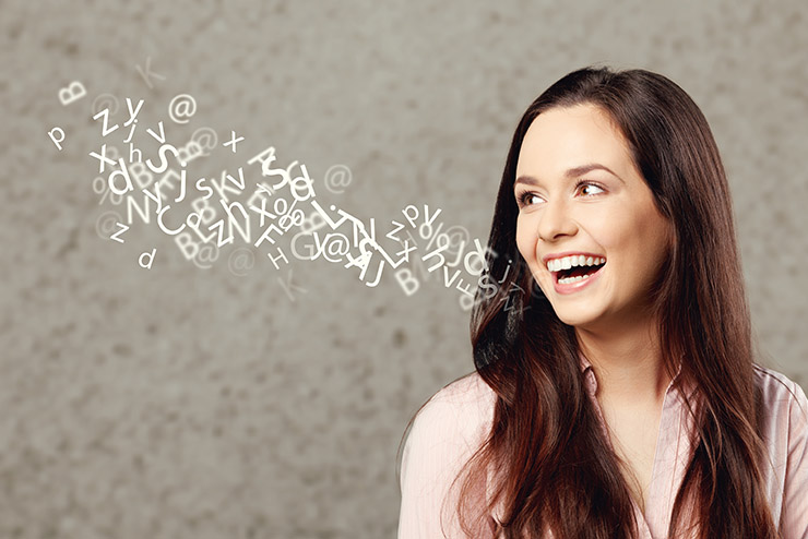 Woman talking with alphabet letters coming out of her mouth.