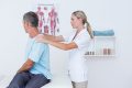Doctor examining her patient neck in medical office